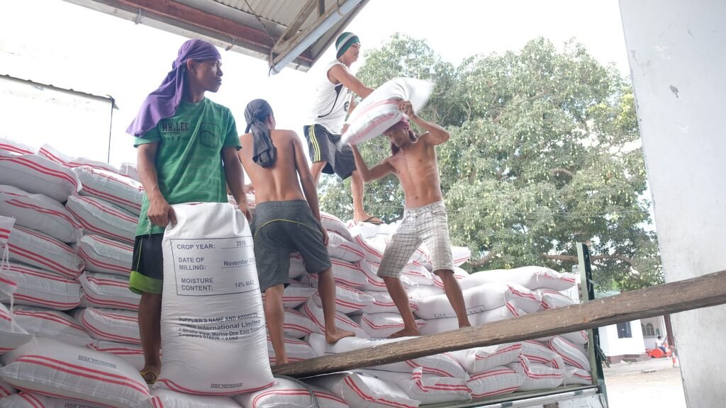 Workers stacking sacks in a warehouse